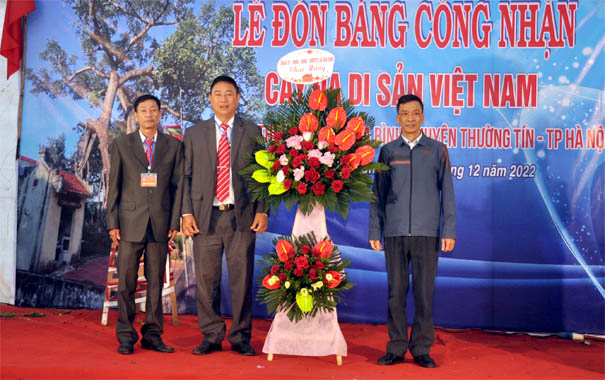 A group of men standing next to a large bouquet of flowersDescription automatically generated with low confidence