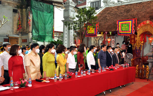 A group of people standing around a table with drinks on itDescription automatically generated with low confidence