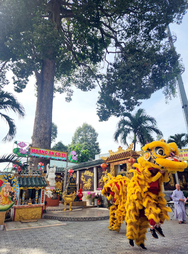 A yellow lion dance in front of a storeDescription automatically generated