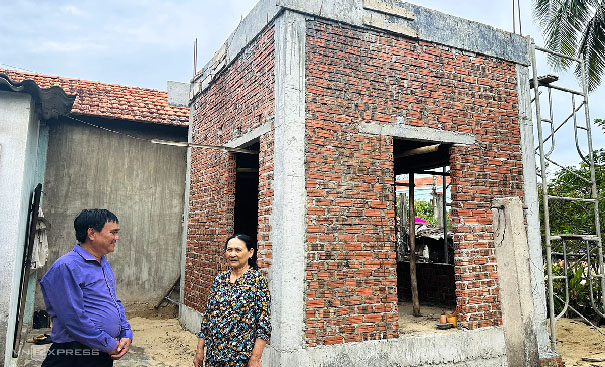 A person and person standing in front of a brick buildingDescription automatically generated