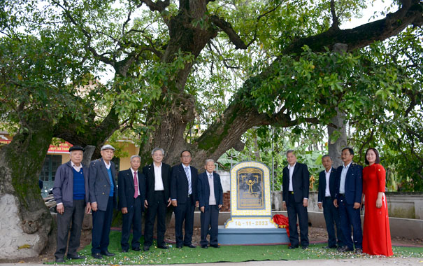 A group of men standing in front of a graveDescription automatically generated