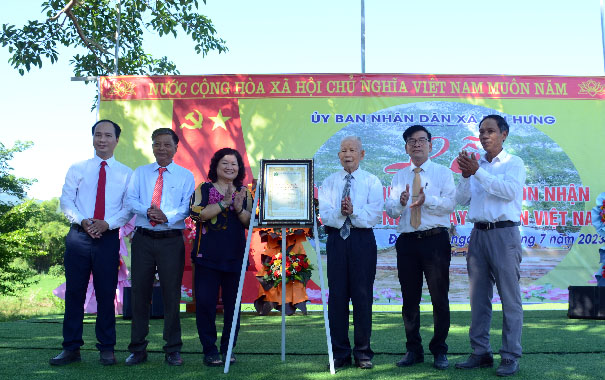 A group of people standing in front of a bannerDescription automatically generated