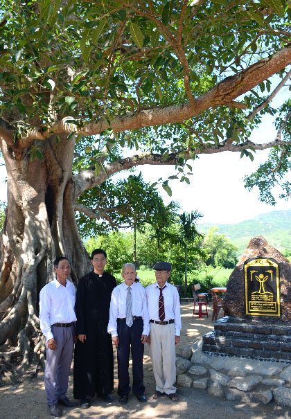 A group of men standing under a treeDescription automatically generated