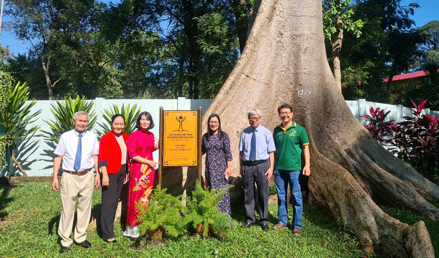 A group of people standing in front of a treeDescription automatically generated