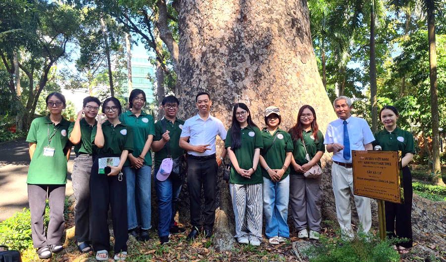 A group of people standing in front of a treeDescription automatically generated