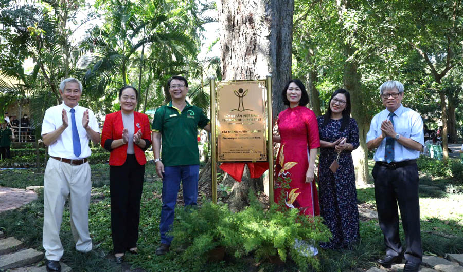 A group of people standing in front of a signDescription automatically generated