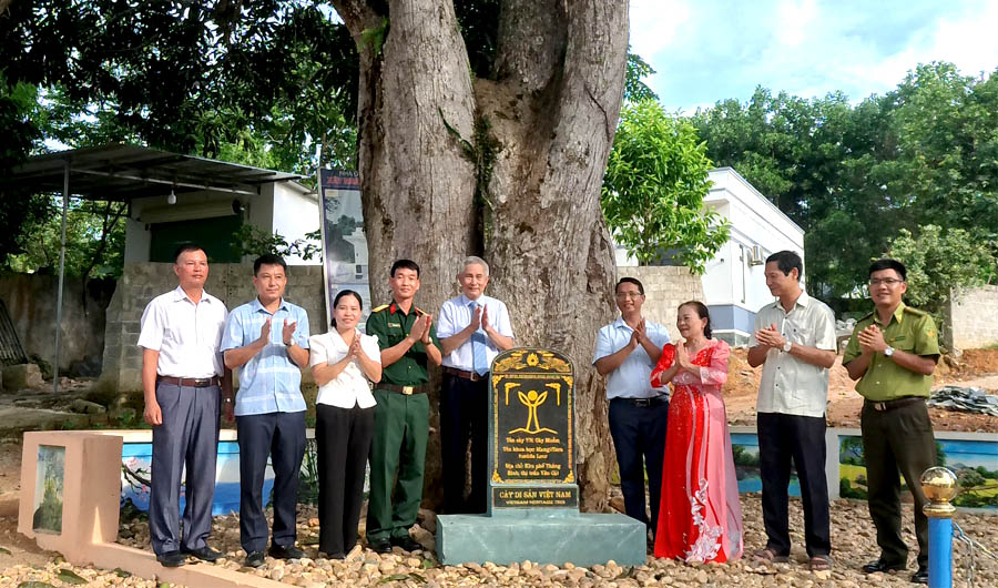 A group of people standing in front of a graveDescription automatically generated