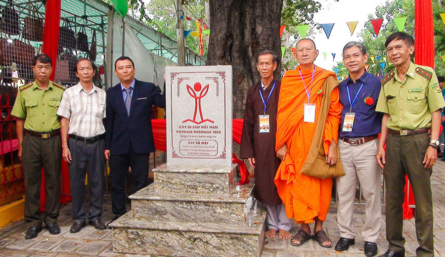 A group of people standing next to a signDescription automatically generated