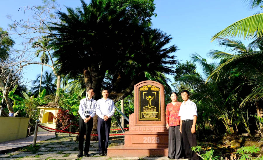 A group of people standing in front of a plaqueDescription automatically generated