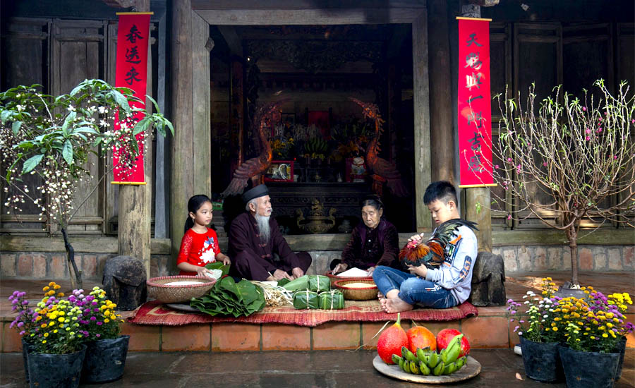 A group of people sitting in front of a buildingDescription automatically generated