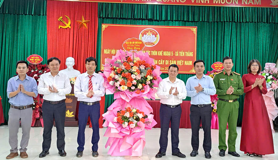 A group of men standing in front of a stage with flowersAI-generated content may be incorrect.