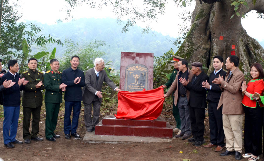 A group of people standing around a monumentDescription automatically generated