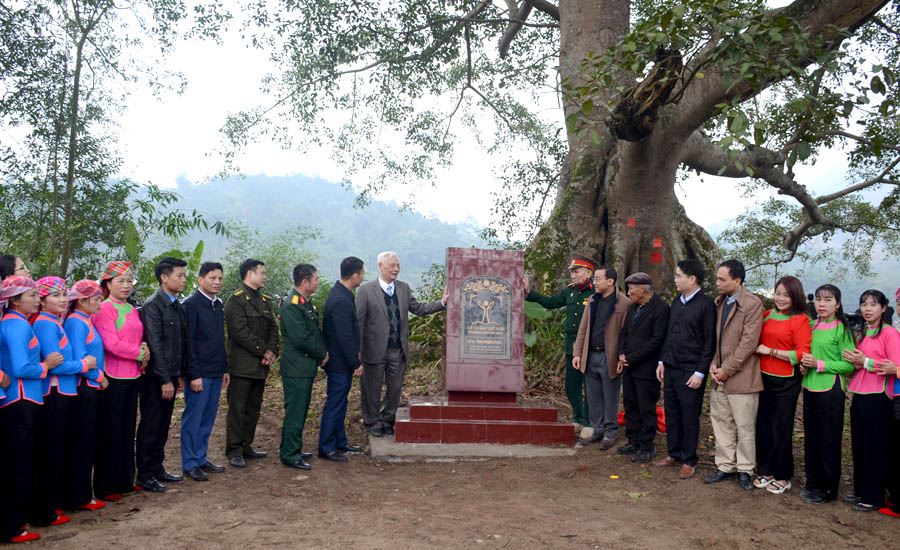 A group of people standing around a monumentDescription automatically generated