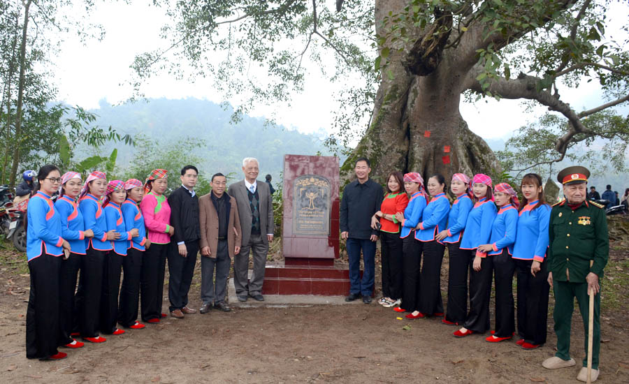 A group of people standing in front of a treeDescription automatically generated