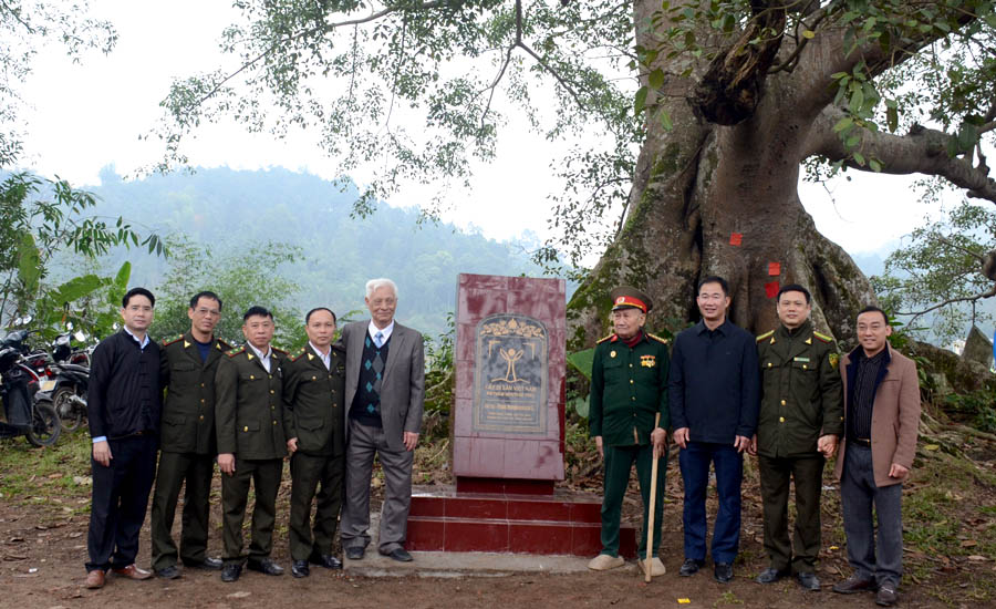 A group of men standing in front of a monumentDescription automatically generated