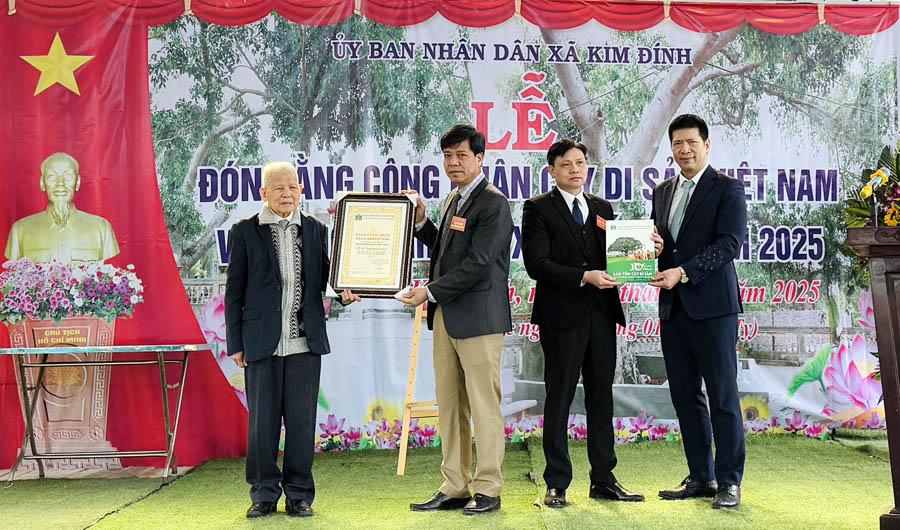 A group of men standing on grass holding a certificateDescription automatically generated