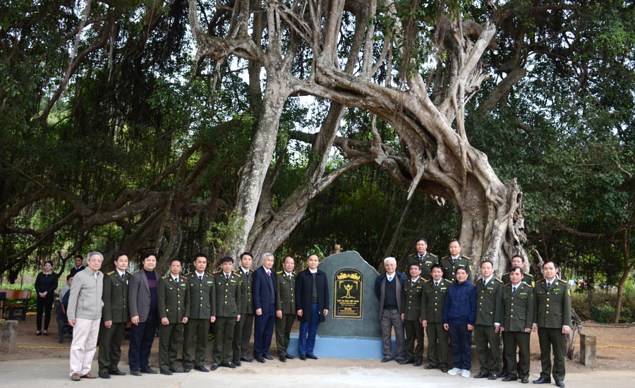 A group of people in uniform standing in front of a graveAI-generated content may be incorrect.