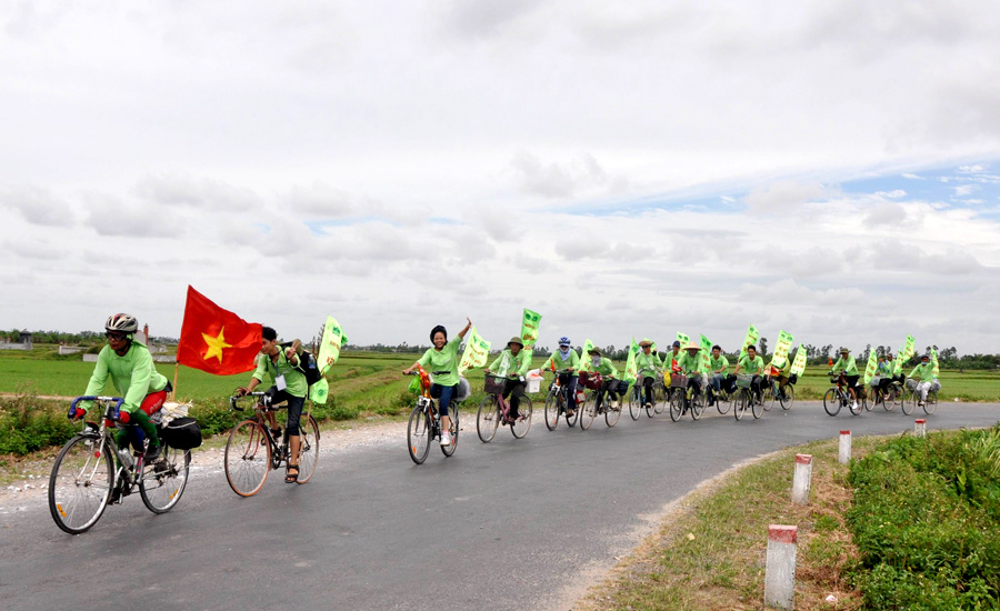 A group of people riding bicycles with flagsAI-generated content may be incorrect.